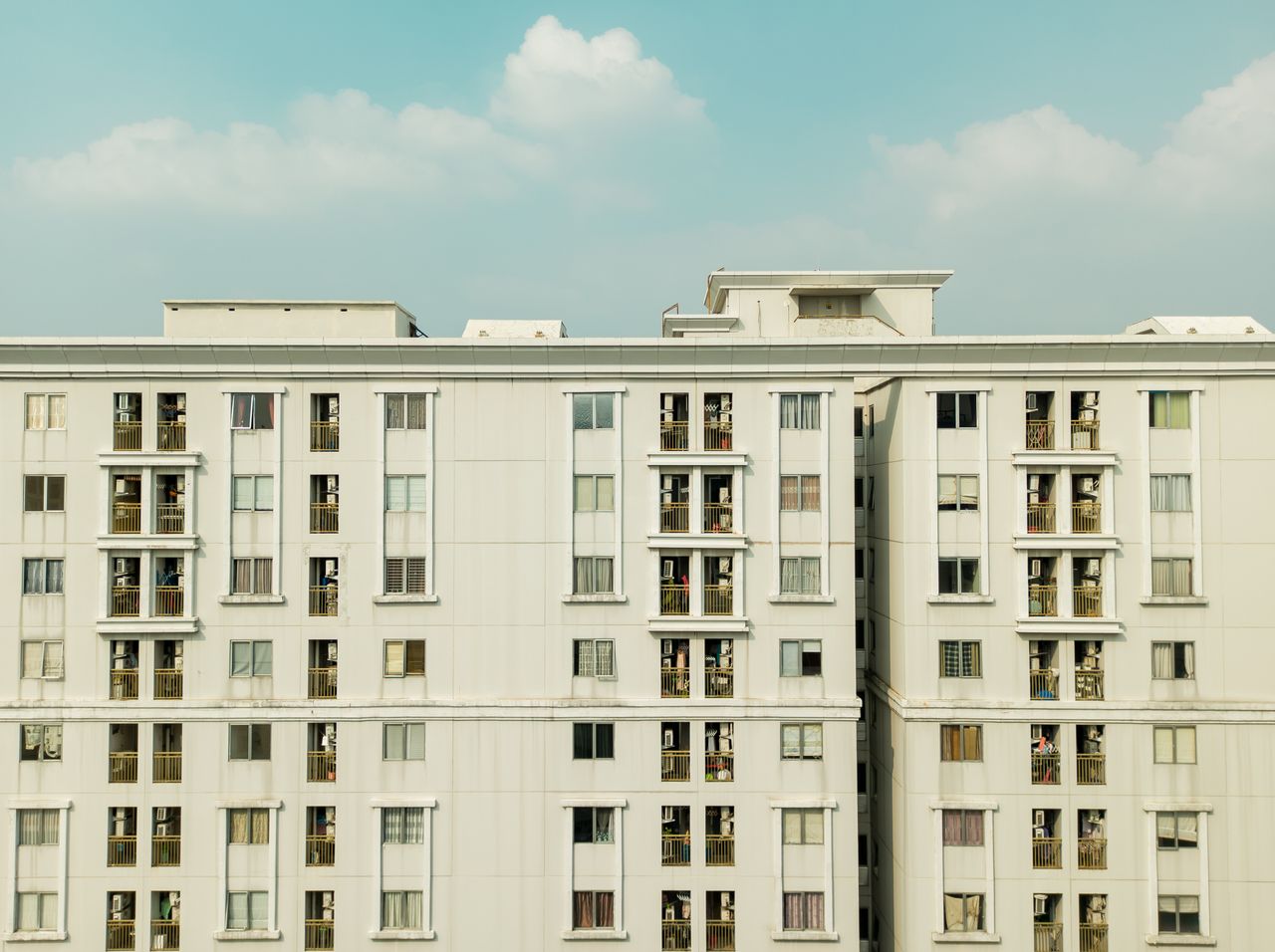 Detailed exterior view of a high-rise building with balconies and windows.